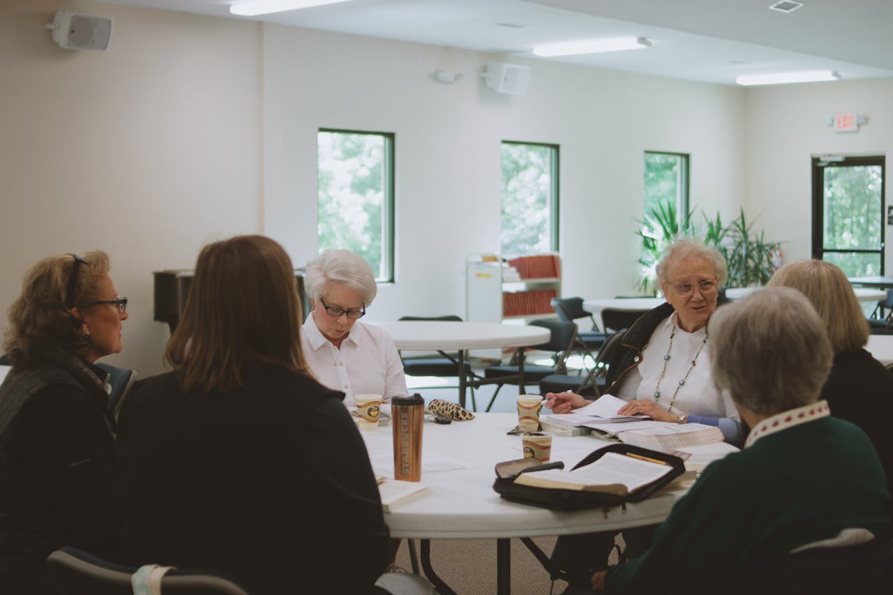 Group of women participating in a Bible study session indoors, fostering community and spiritual growth.